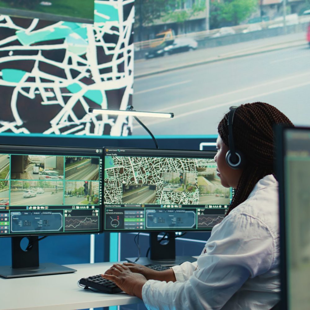 African american operator works on call center at shipping agency, offering real time updates to clients about their order and delivery. Tracking GPS coordinates to arrive at destination. Camera B.